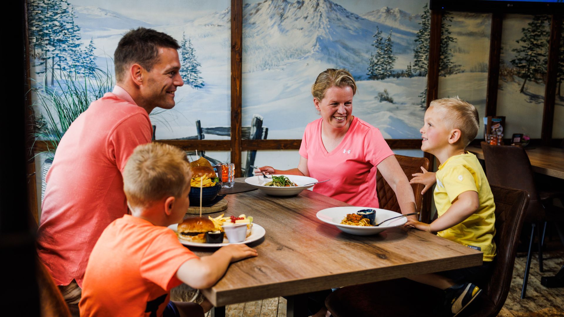 Family is dining in the restaurant with out piste at Montana Snowcenter.