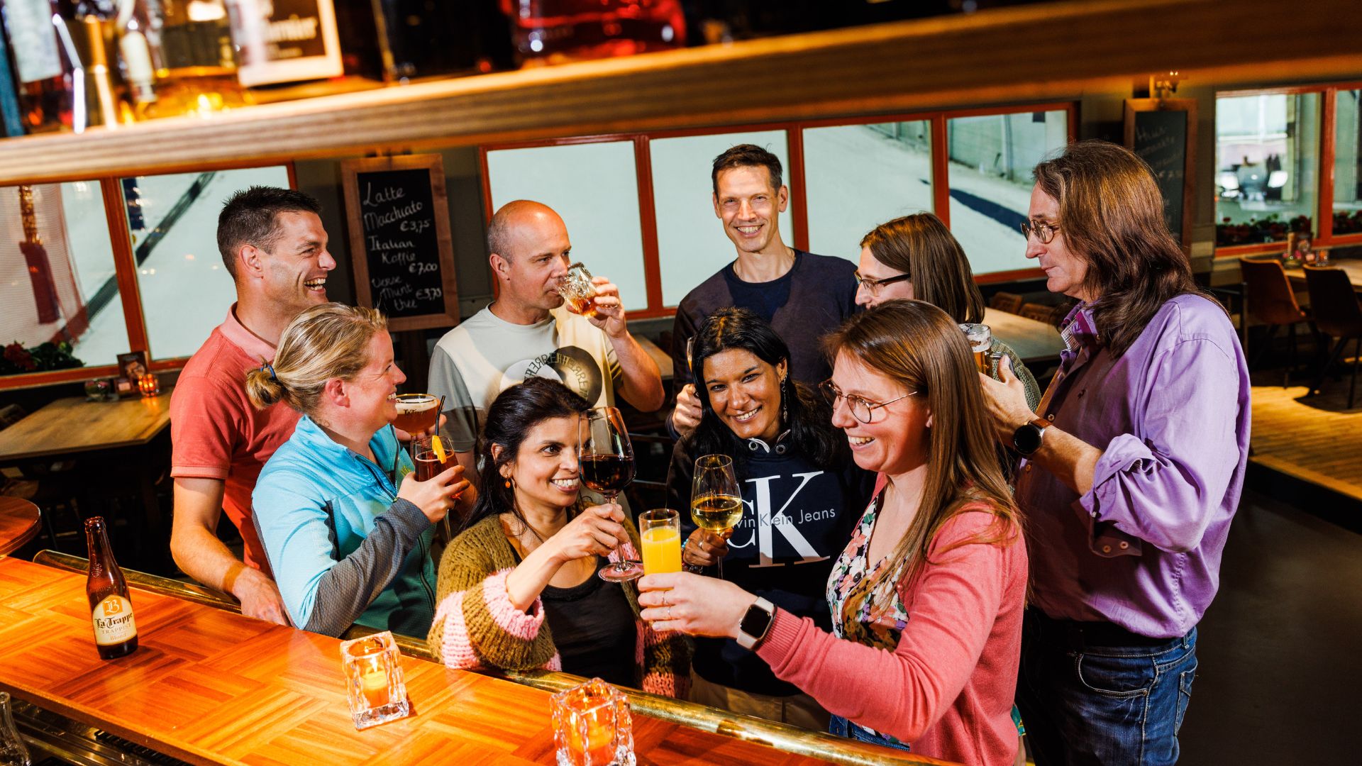 Groep drinkt samen een drankje in de bar met wintersport ambiance. Je kunt deze zaal huren voor feestjes, vergaderingen en andere bijeenkomsten.