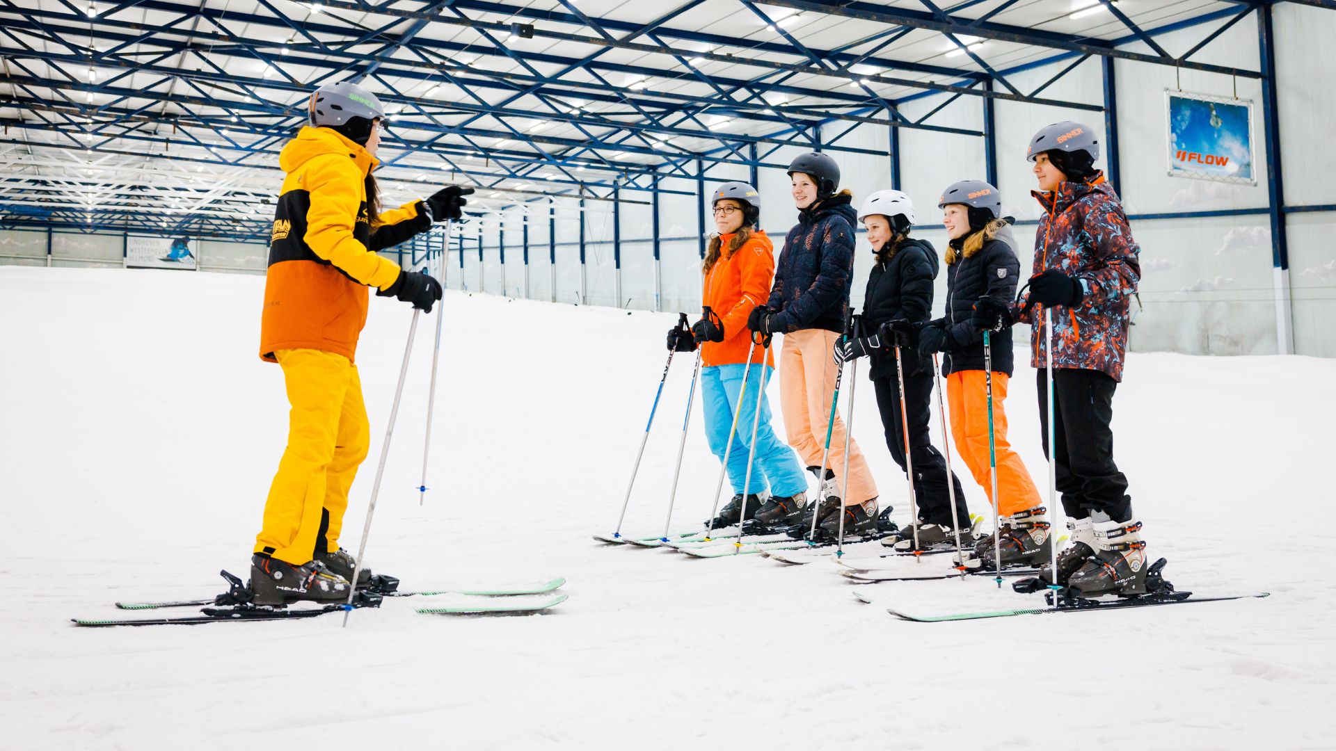 Skileraar geeft skiles aan een groepje leerlingen van een school.