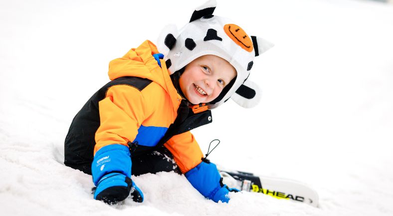 Peuter in de sneeuw. Montana Snowcenter geeft speciale skilessen voor 3-jarige peuters. Voor deze kinderen is dit een leuke en goede kennismaking met de skisport